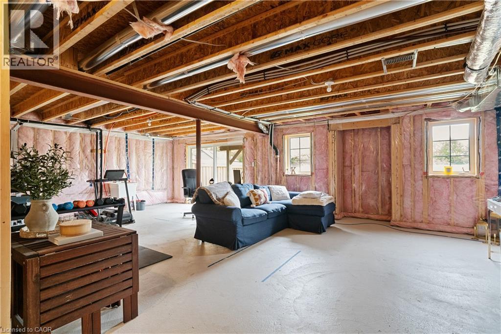 Unfinished basement featuring exposed wood joists, structural steel beam, insulated walls, and two windows - 68 Barkerville Drive, Whitby, ON