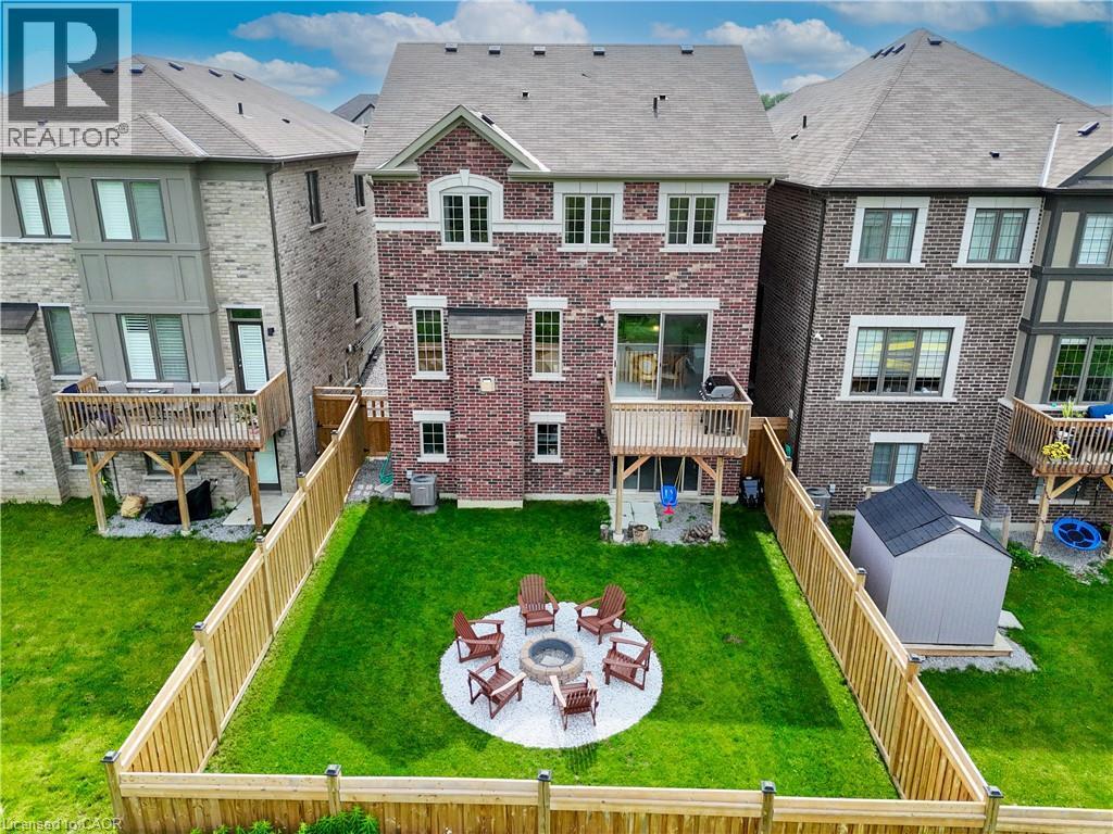 Brick exterior with white window trim, upper-level wood deck, and a fenced backyard - 68 Barkerville Drive, Whitby, ON