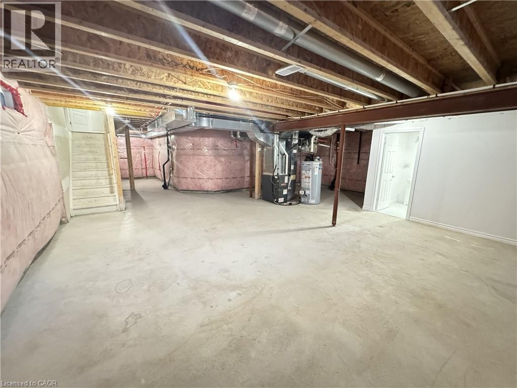 Spacious unfinished basement with exposed wood joists, insulated walls, concrete flooring, and an accessible staircase - 67 Pointer Street, Cambridge, ON