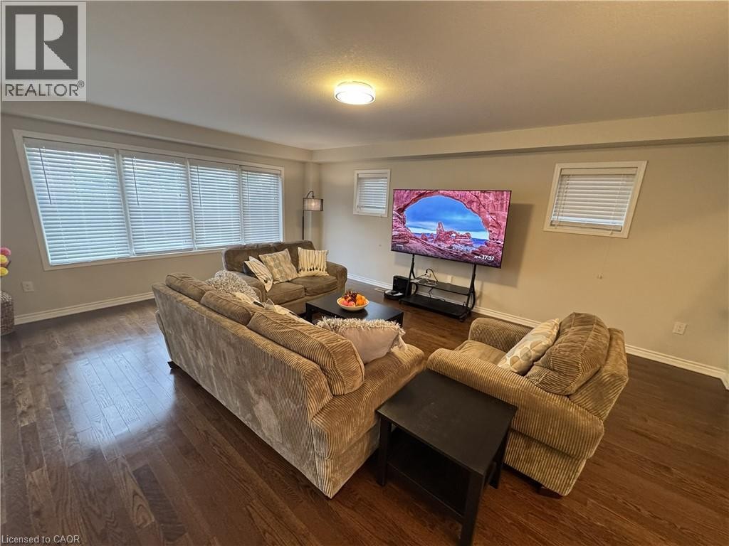 Wood-finish flooring, multiple windows with blinds, and a flush mount ceiling light - 67 Pointer Street, Cambridge, ON