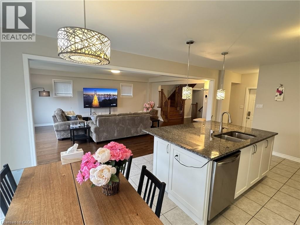 Kitchen island with granite countertop, double basin sink, and pendant lighting - 67 Pointer Street, Cambridge, ON