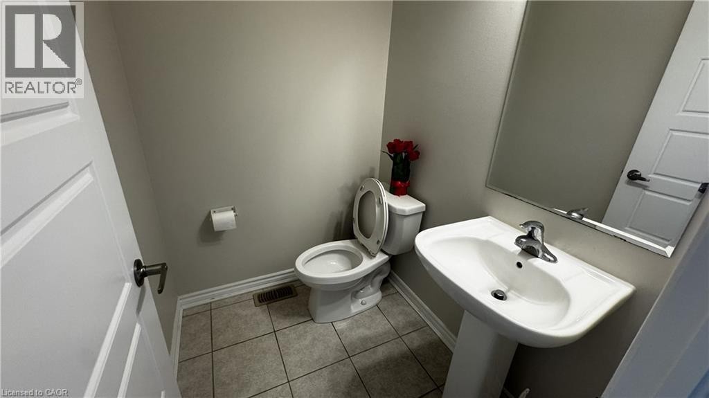 Pedestal sink with chrome faucet, wall-mounted mirror, and tile flooring - 67 Pointer Street, Cambridge, ON