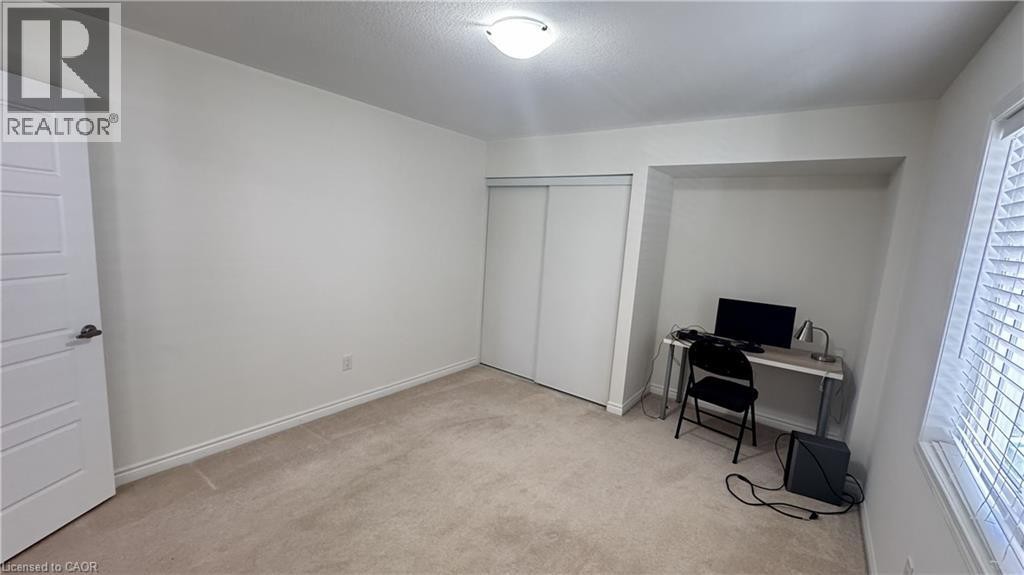 Carpeted room with white walls, a built-in alcove, and a window with blinds - 67 Pointer Street, Cambridge, ON