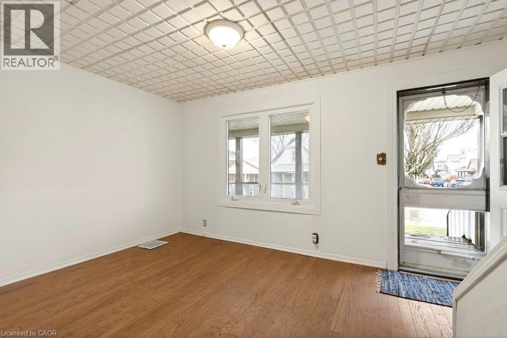 Hardwood-finish flooring, white walls, and a multi-pane window - 23 Frederick Avenue, Hamilton, ON