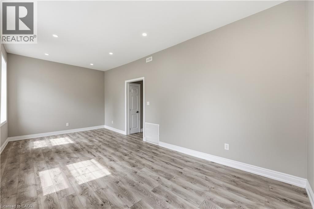 Recessed lighting, wood-finish flooring, light gray wall paint, white trim, and a white interior door - 98 Duke Street Unit# 2Nd, Hamilton, ON