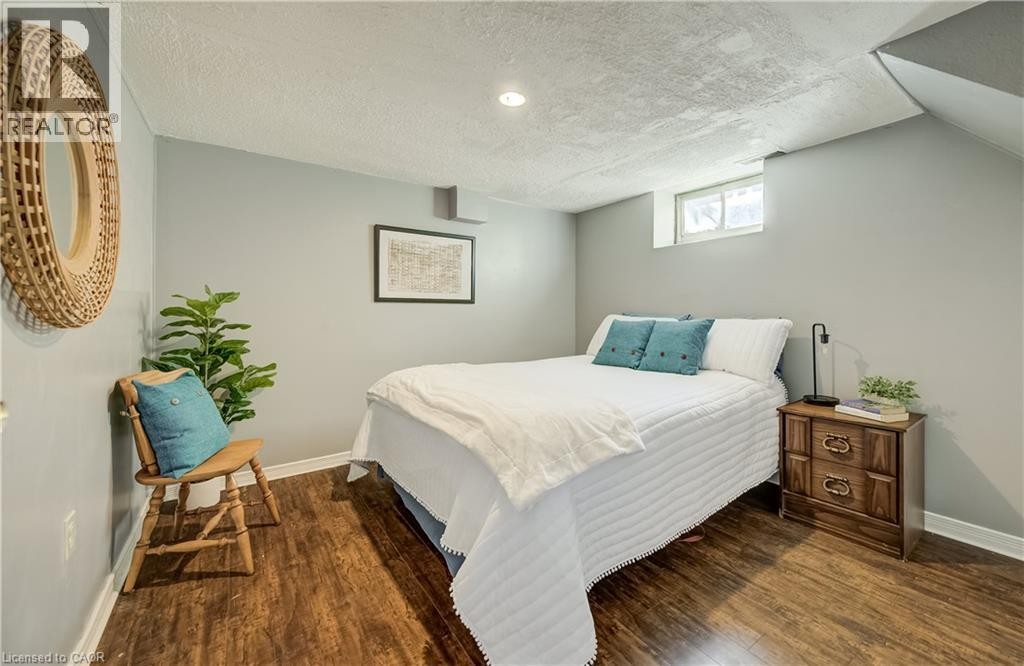 Wood-finish flooring with light gray walls, an egress window, and recessed ceiling lighting - 176 Edwin Street, Kitchener, ON