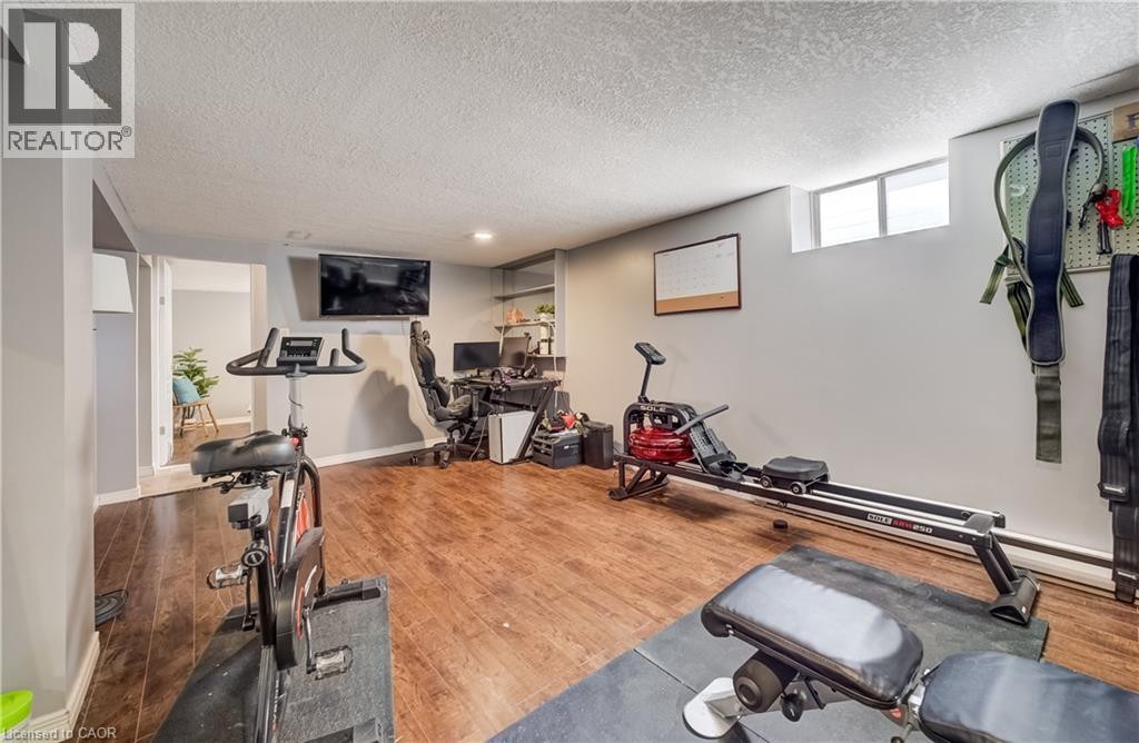 Wood-finish flooring with neutral wall paint, recessed lighting, and a built-in wall shelf - 176 Edwin Street, Kitchener, ON
