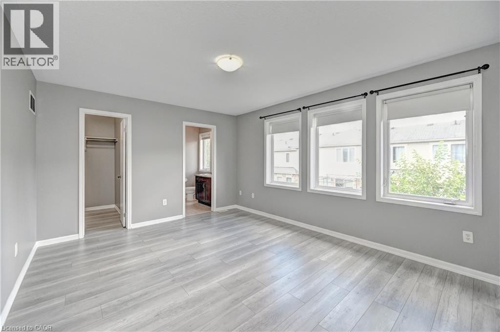 Spacious room featuring light wood-finish flooring, light gray wall paint, and white trim - 103 Blackbird Circle, Cambridge, ON