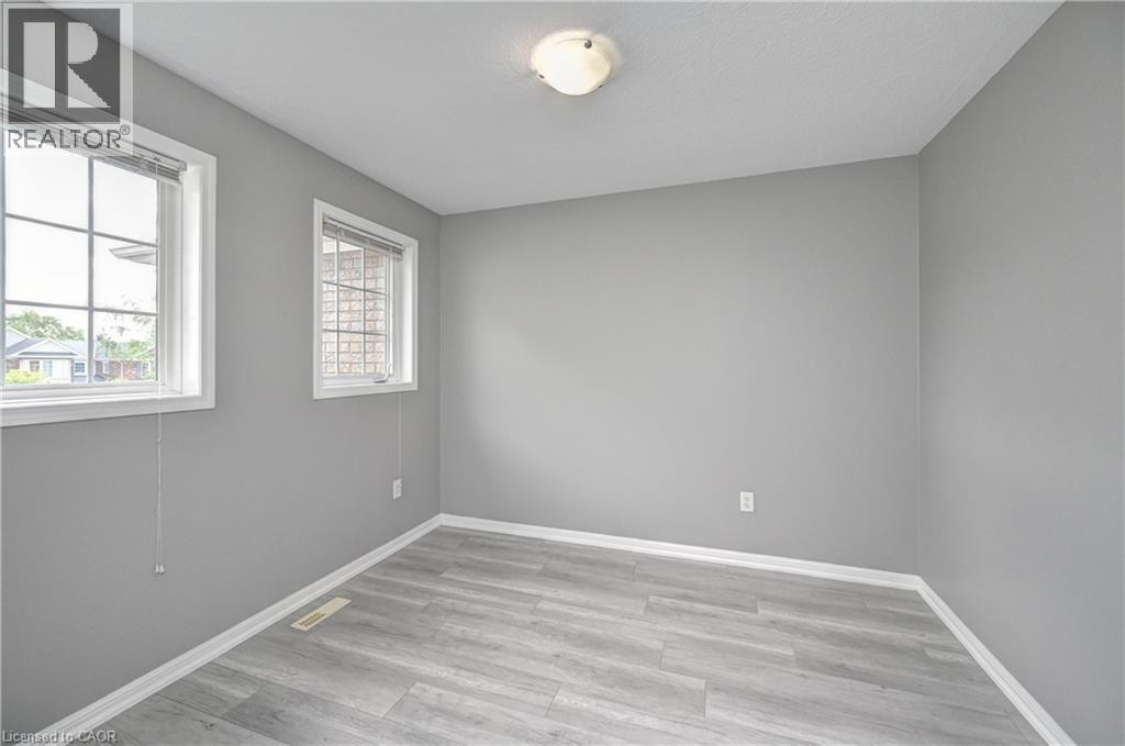 Light gray walls complemented by wood-finish flooring - 103 Blackbird Circle, Cambridge, ON