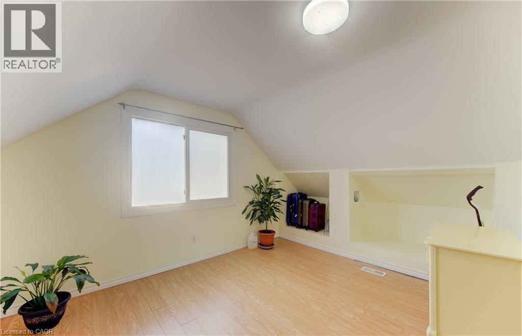 Sloped ceilings, wood-finish flooring, a double window, built-in recessed shelving, and a flush-mount ceiling light - 104 Mausser Avenue, Kitchener, ON