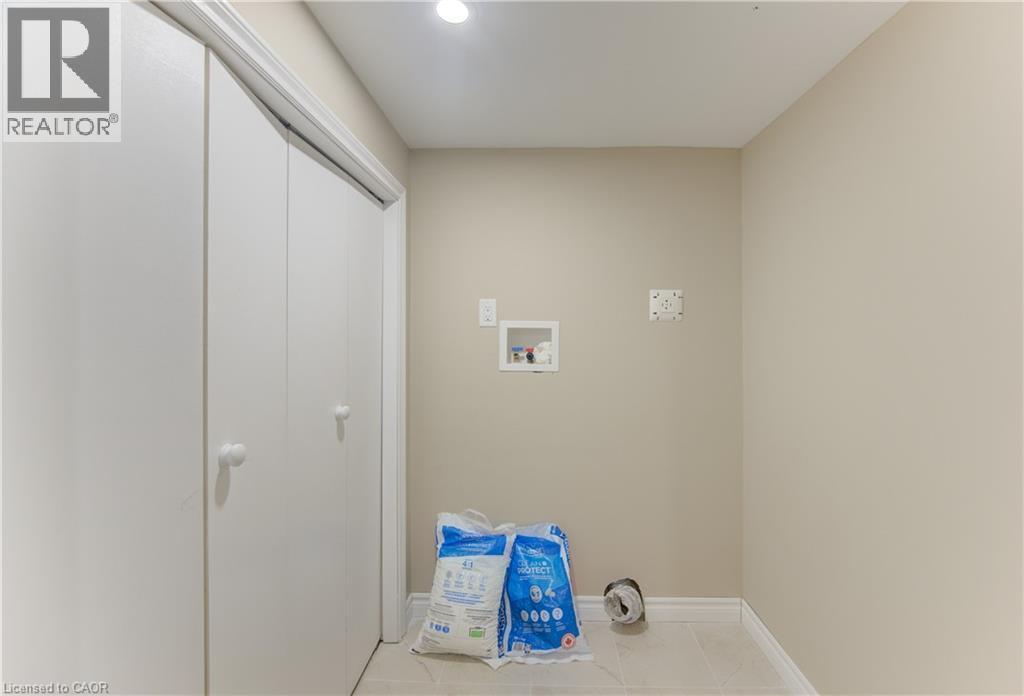 Laundry area with light-toned walls, tile flooring, and integrated utility connections - 104 Mausser Avenue, Kitchener, ON