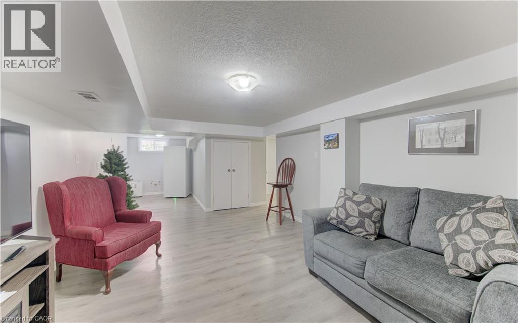 Spacious room featuring light wood-finish flooring, recessed lighting, and bright white walls - 104 Mausser Avenue, Kitchener, ON