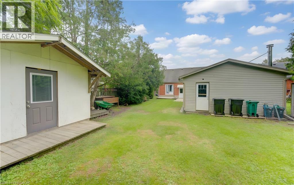 Expansive grass lawn with two detached outbuildings featuring exterior doors - 104 Mausser Avenue, Kitchener, ON