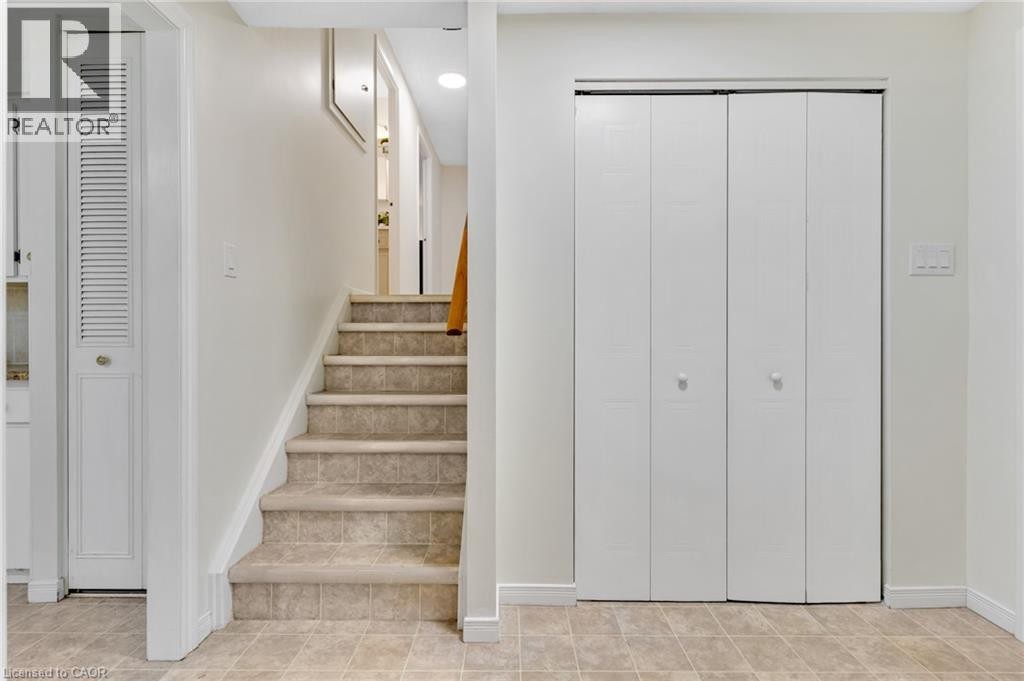 Ceramic tile flooring, carpeted stairs, bi-fold closet doors, and a louvered door - 7 Underhill Crescent, Kitchener, ON