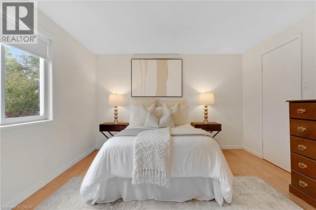White walls with a window featuring a roller shade and wood-finish flooring - 7 Underhill Crescent, Kitchener, ON