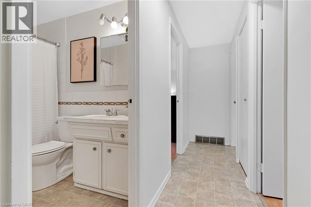 Bathroom featuring a white vanity with integrated sink, chrome faucet, and overhead track lighting - 7 Underhill Crescent, Kitchener, ON