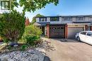 Brick and siding exterior with a dark-paneled garage door, complemented with a gabled roof and dark shutters contrasted on bright siding. - 148 St Andrews Drive, Hamilton, ON 