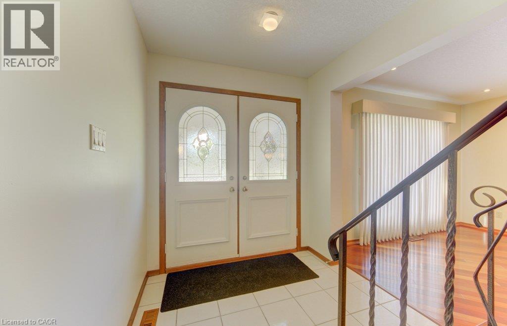 Double entry doors with decorative leaded glass inserts, tile flooring, and a wrought iron railing - 238 Mcgarry Drive, Kitchener, ON