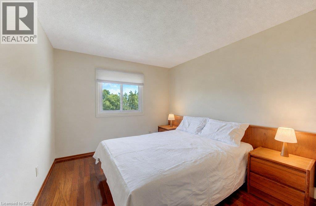 Wood-finish flooring with neutral wall tones and a window with roller shade - 238 Mcgarry Drive, Kitchener, ON