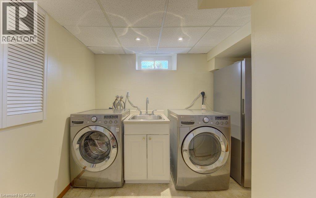 Utility area featuring a built-in sink with a base cabinet, recessed lighting, and a louvered panel - 238 Mcgarry Drive, Kitchener, ON