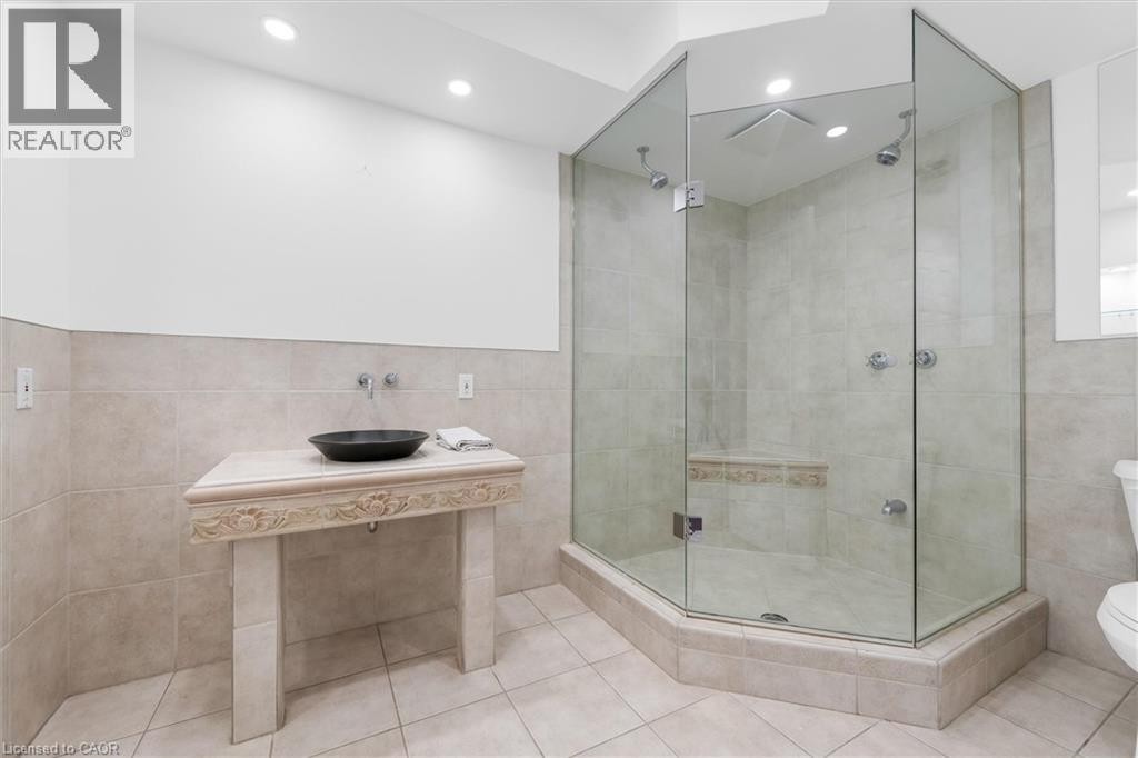 Glass-enclosed shower with a built-in bench, dual shower heads, and recessed lighting - 1389 Lakeshore Road, Burlington, ON