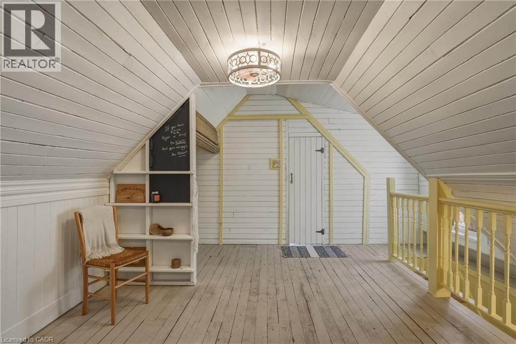 Sloping planked ceilings, wood-finish flooring, built-in shelving, a built-in storage door, and a built-in banister - 42 Nightingale Street, Hamilton, ON