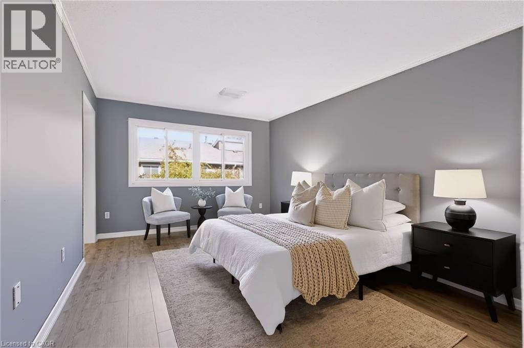Wood-finish flooring, white trim, window, and wall-mounted lighting - 121 University Avenue E Unit# 102, Waterloo, ON