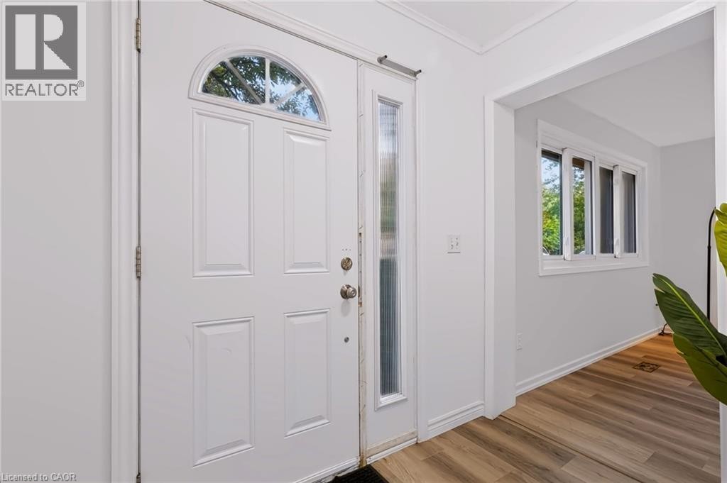 White paneled entry door with an arched transom, a full-length sidelight, and wood-finish flooring - 121 University Avenue E Unit# 102, Waterloo, ON