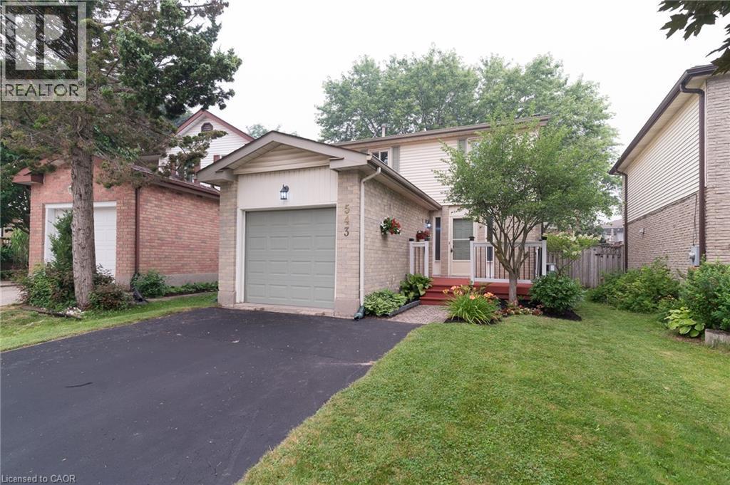 Brick and siding exterior with an attached garage, paved driveway, and established front landscaping - 543 Drummerhill Crescent, Waterloo, ON