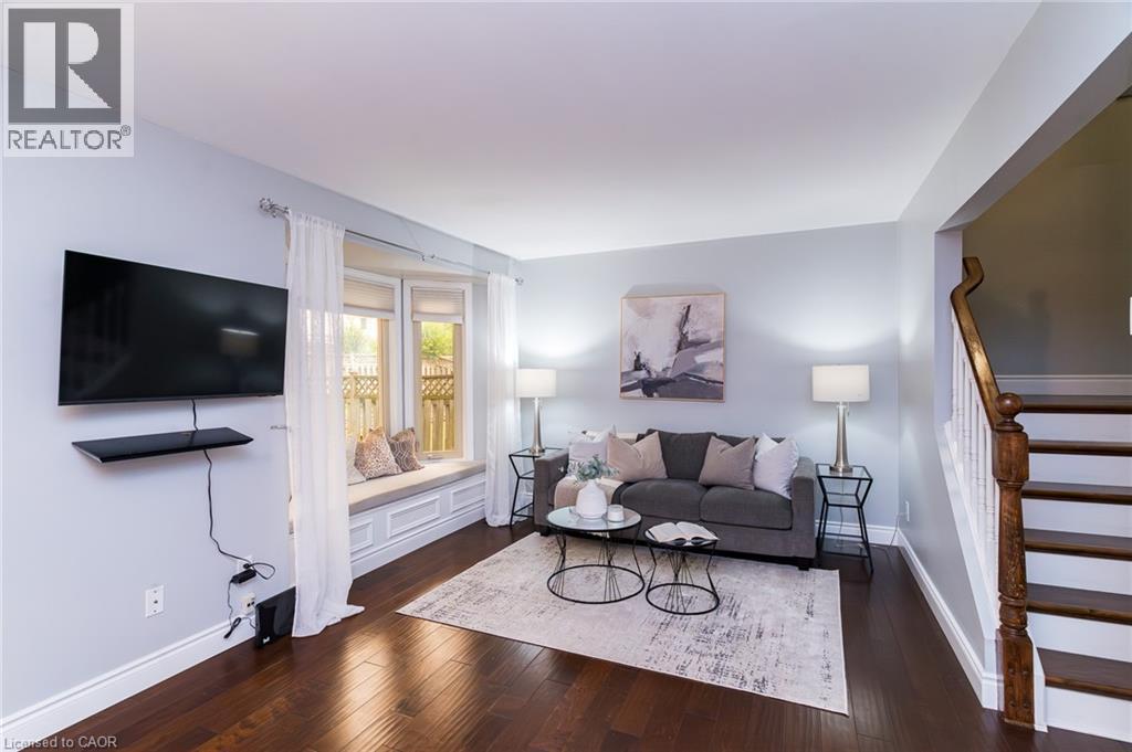 Dark wood-finish flooring, a built-in window seat, and a wall-mounted entertainment shelf - 543 Drummerhill Crescent, Waterloo, ON