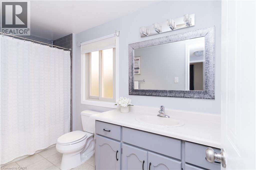 Bathroom featuring a single vanity with light gray cabinetry, white countertop, and a built-in sink - 543 Drummerhill Crescent, Waterloo, ON