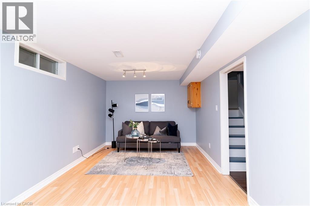 Recessed window, wood-finish flooring, track lighting, light blue wall paint, and a built-in wood cabinet - 543 Drummerhill Crescent, Waterloo, ON