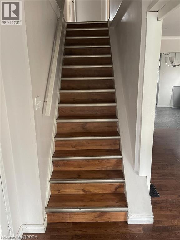 Staircase featuring wood-finish treads with metallic trim - 258 Wellington Road, London, ON