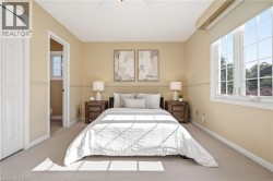 Neutral-toned carpeting, ample natural light from multi-pane windows, and a ceiling fan -
