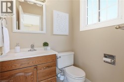 Bright and functional bathroom featuring a wood-finish vanity with ample storage, ceramic sink with chrome fixtures, and a white porcelain toilet -