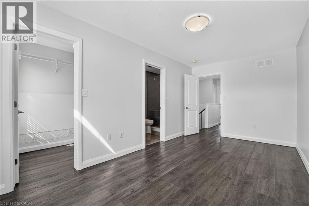 Wood-finish flooring, white walls, flush mount ceiling light, white trim, and built-in closet shelving - 1169 E Garner Road E Unit# 66, Ancaster, ON