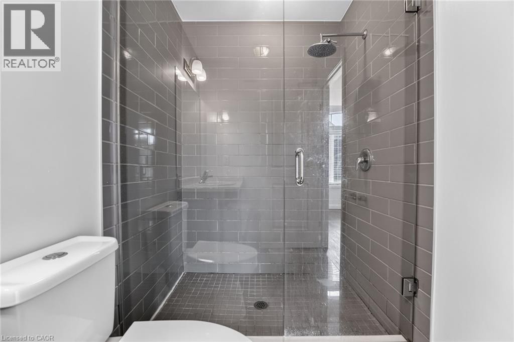 Glass-enclosed shower featuring subway tile surround, rain shower head, and polished chrome fixtures - 1169 E Garner Road E Unit# 66, Ancaster, ON