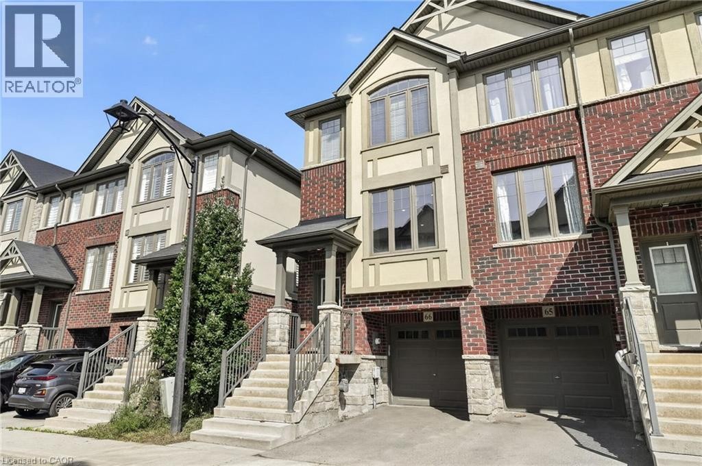 Brick and stucco exterior with multiple windows, an integrated garage, and an inviting front porch - 1169 E Garner Road E Unit# 66, Ancaster, ON