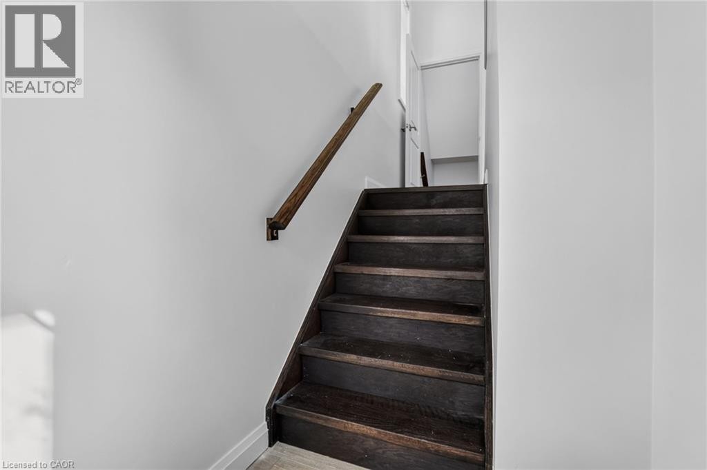 Dark wood-finish staircase with a matching wood handrail - 1169 E Garner Road E Unit# 66, Ancaster, ON