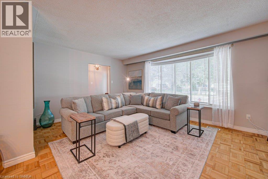 Recessed bay window with blinds, light wall color, wood-finish parquet flooring, and a coved ceiling - 3158 Palmer Drive, Burlington, ON