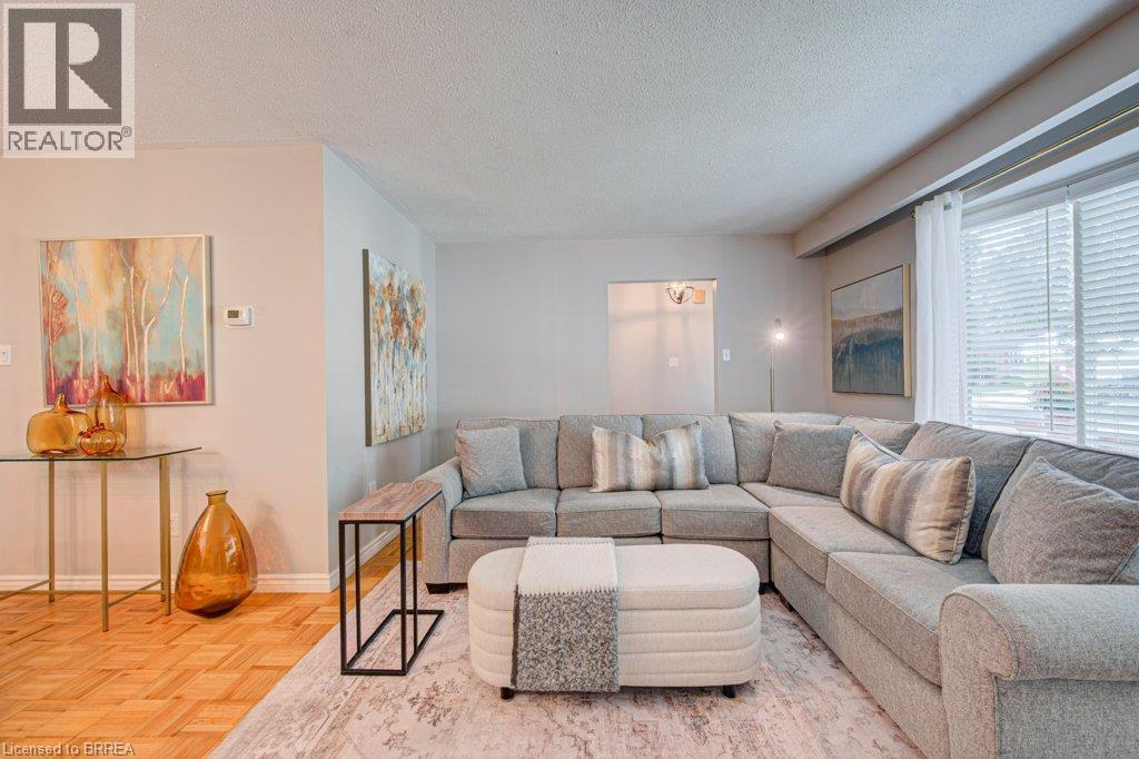 Parquet wood flooring, neutral wall tones, large windows with blinds, recessed lighting, and a broad coved ceiling - 3158 Palmer Drive, Burlington, ON
