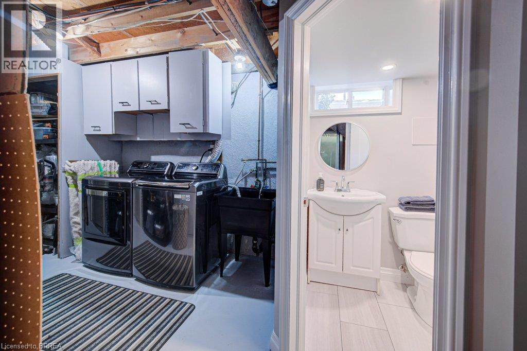 Laundry area featuring white cabinetry and utility sink - 3158 Palmer Drive, Burlington, ON