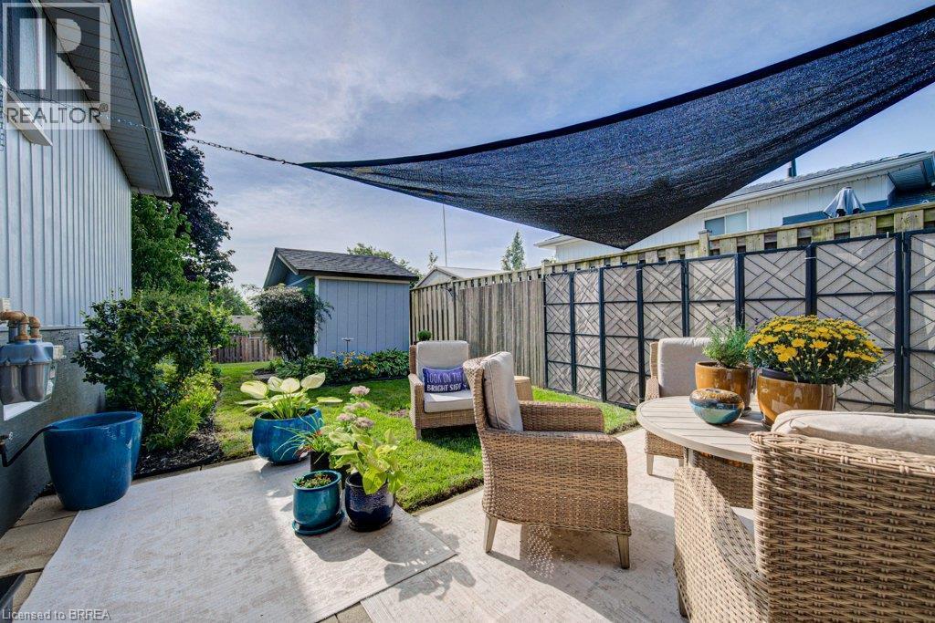 Manicured lawn, mature landscaping, wood privacy fence, decorative fence panels, and a concrete patio - 3158 Palmer Drive, Burlington, ON