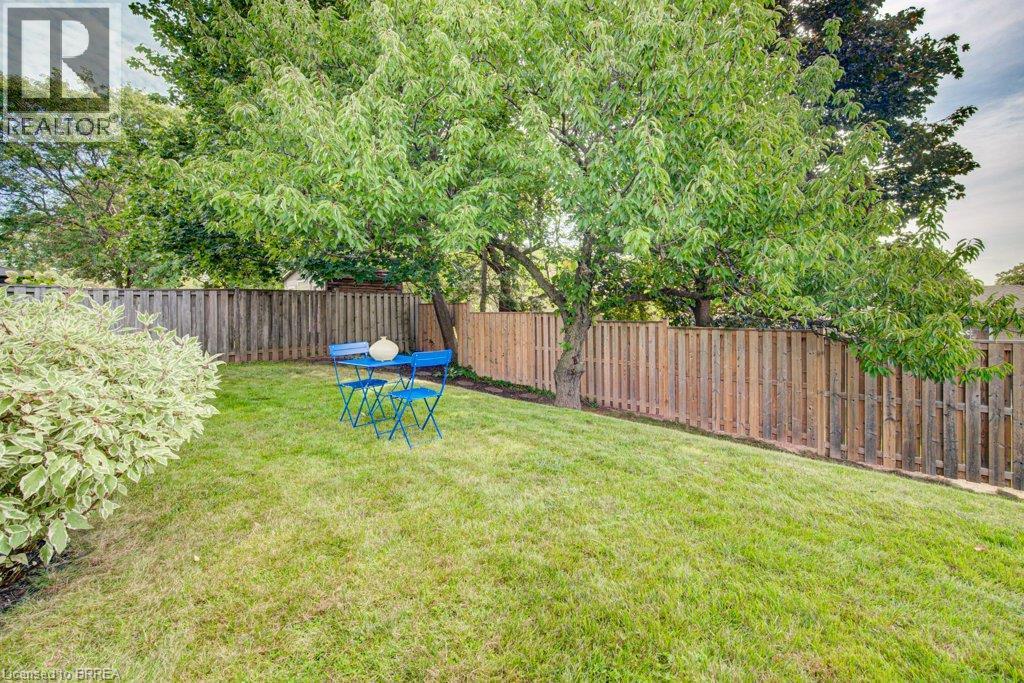 Expansive yard featuring a manicured lawn, mature trees, and privacy fencing - 3158 Palmer Drive, Burlington, ON