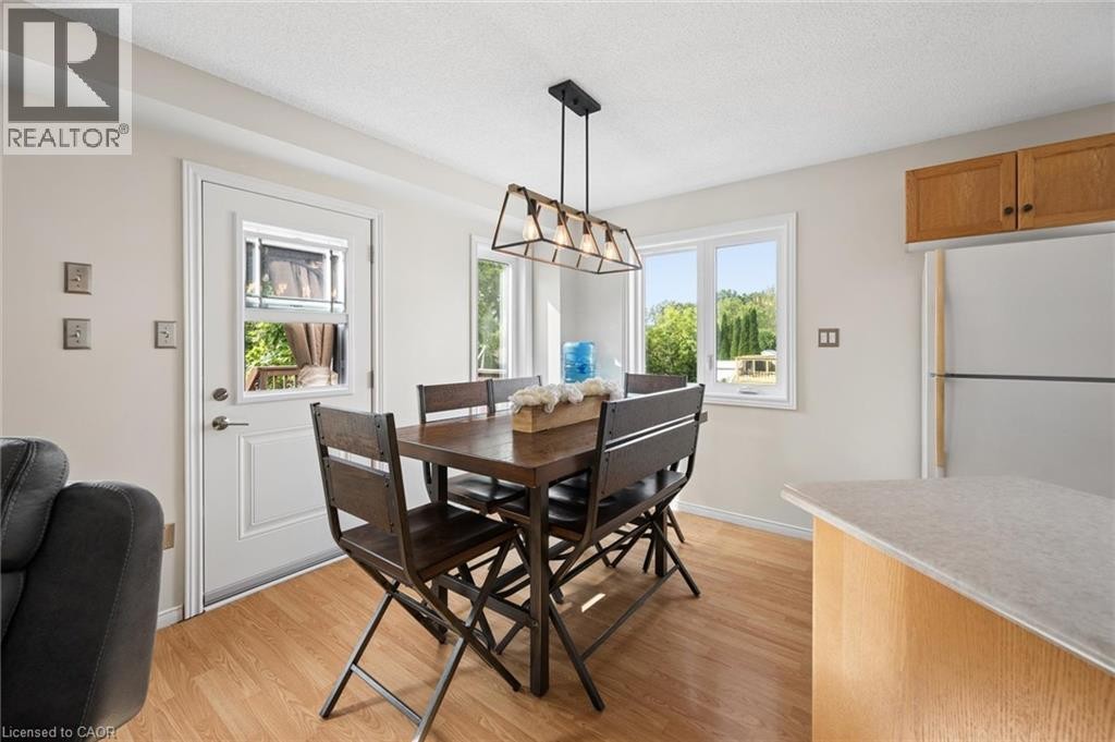 Wood-finish flooring, white walls, and a multi-light linear pendant fixture - 67 Apple Tree Drive, Kitchener, ON