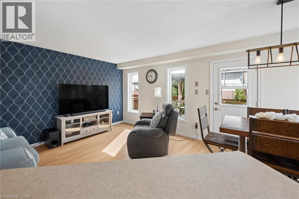 Decorative accent wall, wood-finish flooring, multiple windows, built-in media console, ceiling-mounted light fixture - 67 Apple Tree Drive, Kitchener, ON