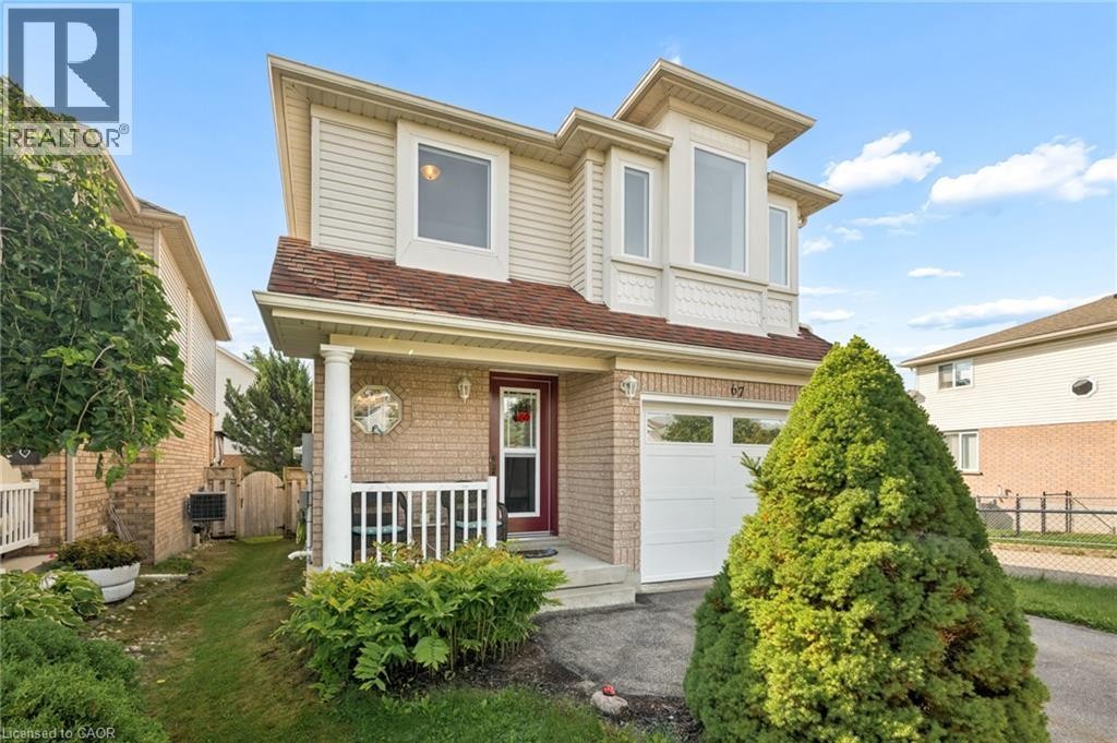 Brick and siding exterior with a covered porch, white column, and an attached garage with a white door - 67 Apple Tree Drive, Kitchener, ON