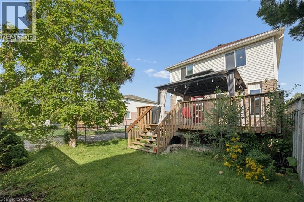Elevated wood-finish deck with pergola, wood-finish stairs, and a level lawn area - 67 Apple Tree Drive, Kitchener, ON