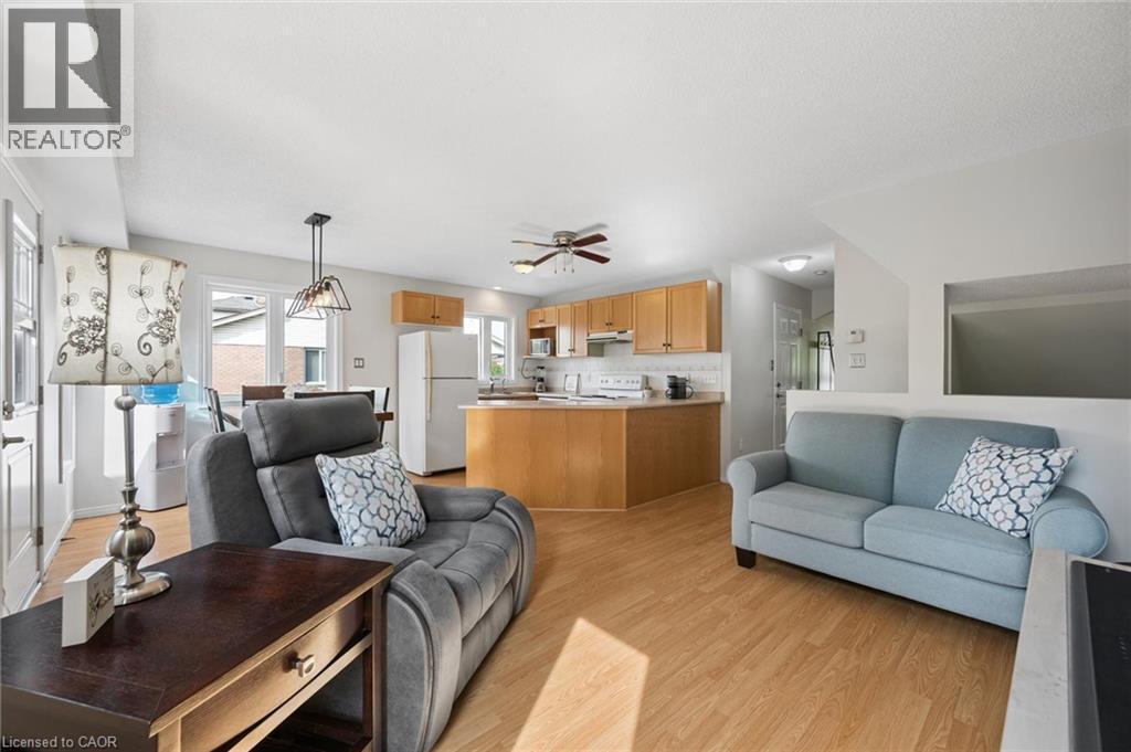 Open-concept living space featuring wood-finish flooring, a kitchen island, and light wood cabinetry - 67 Apple Tree Drive, Kitchener, ON