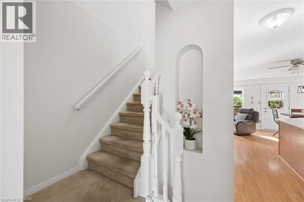 Carpeted staircase with white balusters - 67 Apple Tree Drive, Kitchener, ON